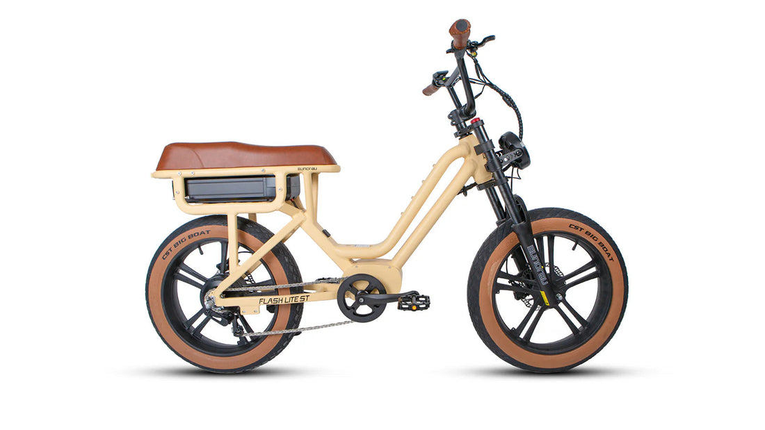 Profile view of the Eunorau FLASH LITE ST 1.0 moped-style e-bike in a tan/beige colorway, featuring a step-through frame, plush brown extended saddle, and brown-sidewall CST Big Boat fat tires against a white background.